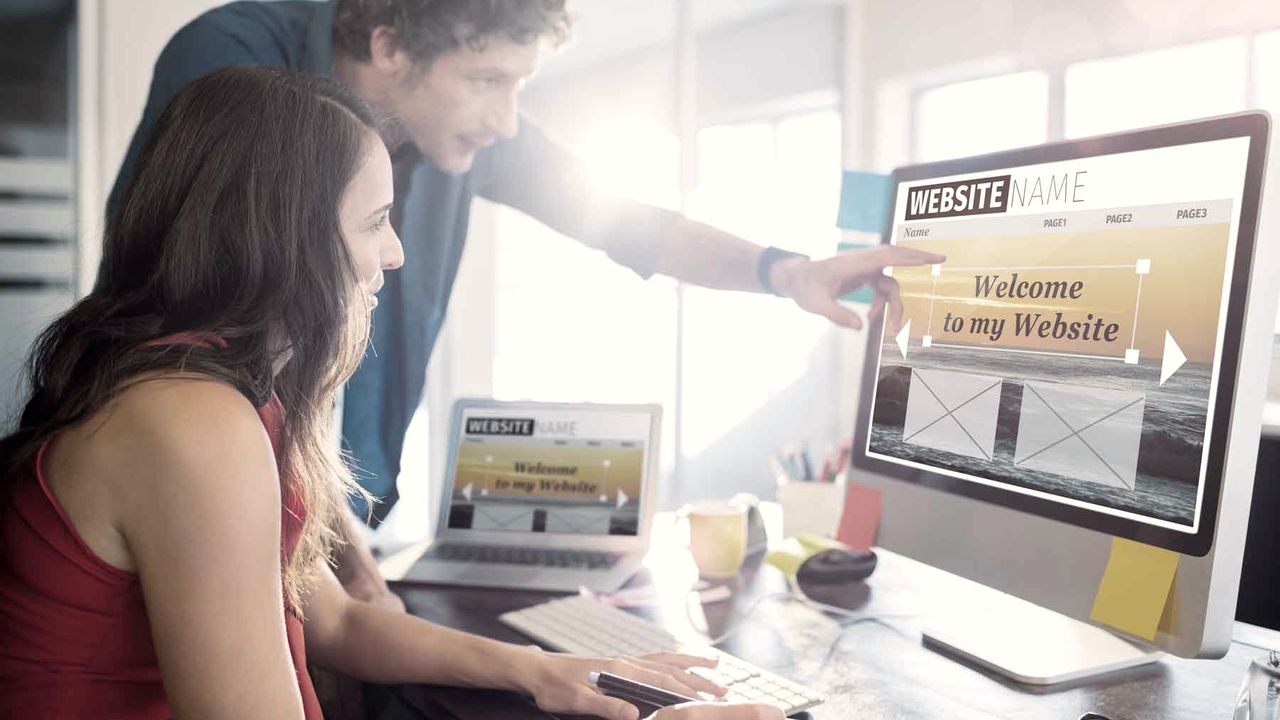 Zwei Personen besprechen eine Website am Bildschirm